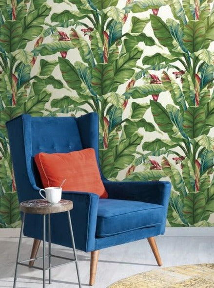 Beautiful green wallpaper with banana leaves behind blue chair
