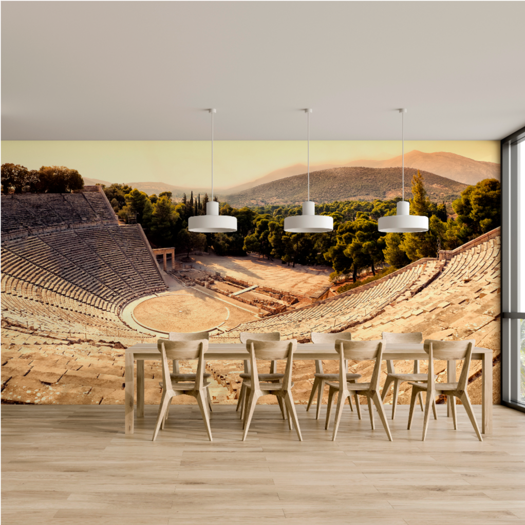 A serene outdoor patio with a large round table and chairs, designed in the style of ancient Greek architecture, overlooking a coastal landscape with cliffs, sea, and clear skies during sunset featuring the Greek Theater Epidavros Theater wallpaper mural by Decor2Go.