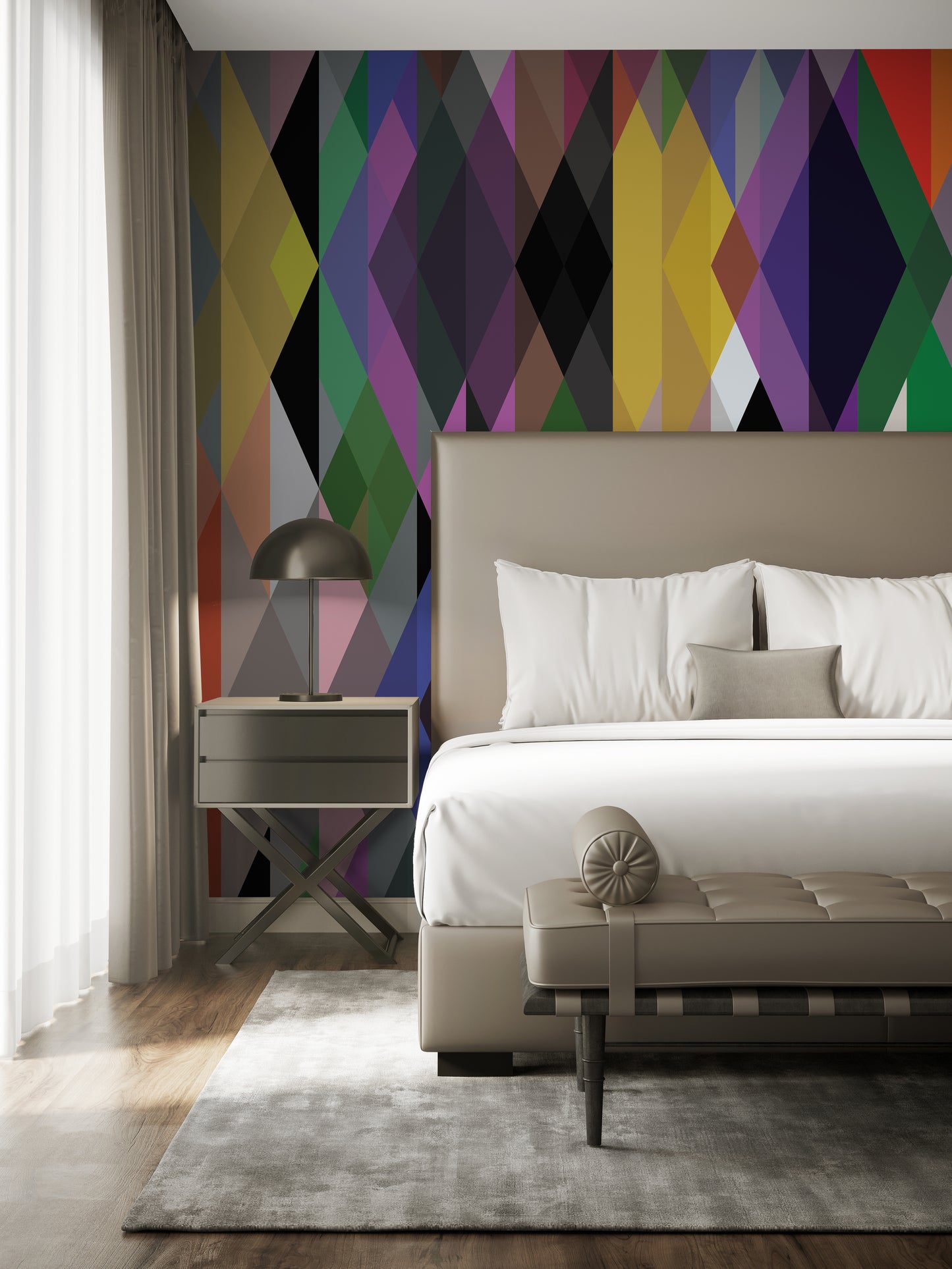 A modern bedroom showcases a vibrant color palette enhanced by the Decor2Go Wallpaper Mural's Modern Geometric Shapes design as an accent wall. The room includes a beige upholstered bed accompanied by coordinating pillows and bolsters, a nightstand with a lamp, and sheer curtains. A gray area rug partially covers the wooden floor, adding to the room's contemporary feel.