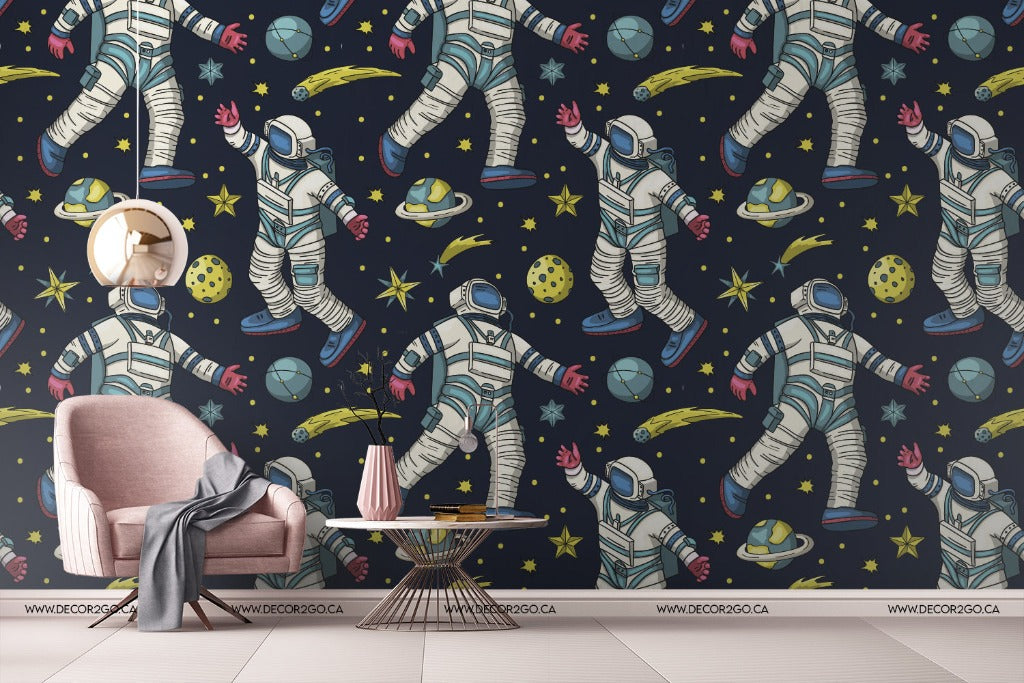 A stylish room featuring a wall covered in Decor2Go Wallpaper Mural's Space Dream Wallpaper Mural, specifically designed as bedroom wall decor, a pink armchair, a gray throw blanket, and a small round coffee table with a vase and