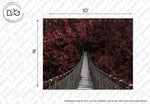A narrow suspension bridge stretches into a dense forest of red and purple foliage, creating an eerie yet captivating pathway. The dimensions of the image are marked as 10 feet wide and 8 feet high, perfect for enhancing your living space with vibrant autumn colors. Watermarked by "Red Forest Wallpaper Mural from Decor2Go Wallpaper Mural.