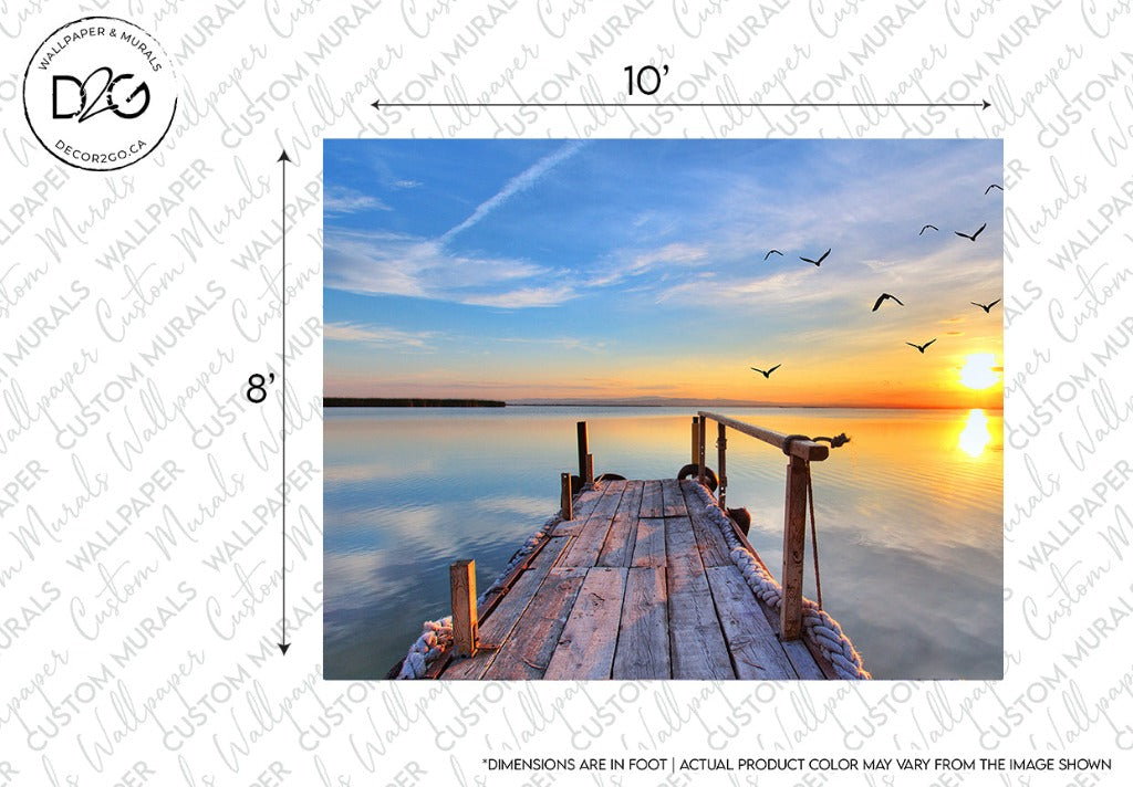 An old wooden pier extends into a tranquil lake under a vibrant sunset sky. A flock of birds flies across the vivid orange and blue horizon, reflected in the still water. This iconic scene of natural beauty is captured in a Sunset Birds Flying Wallpaper Mural by Decor2Go Wallpaper Mural, framed with dimensions noted: 10 feet wide and 8 feet tall.