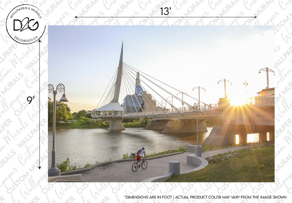 A serene sunset view featuring a cyclist on a pathway beside a river, with the Decor2Go Wallpaper Mural Urban Bridge in the background and the sun casting vibrant rays across the scene.
