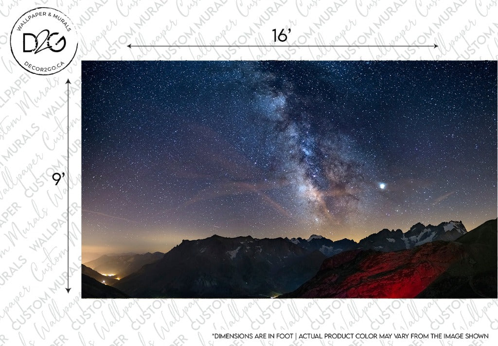 Nighttime view of the Milky Way Wallpaper Mural above mountainous terrain, with clear starry sky and a distinct galaxy core. The foreground shows mountains and subtle illumination from a distant village. Created by Decor2Go Wallpaper Mural.