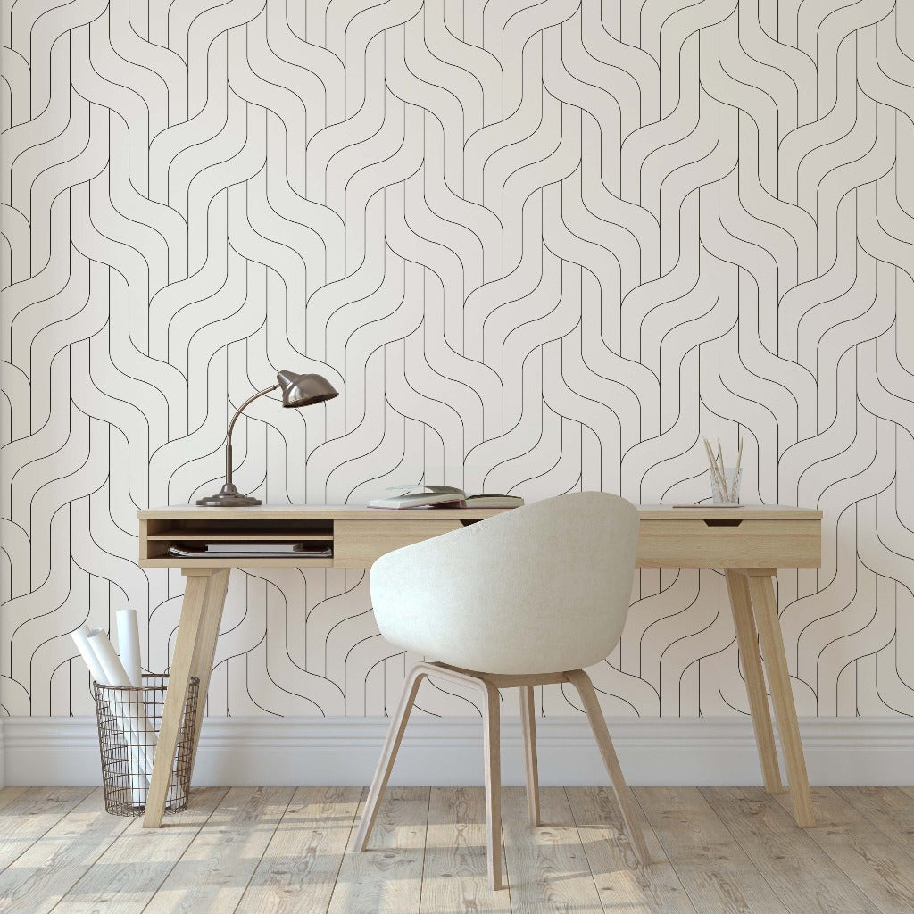 A minimalist home office with a light wood desk and a cream chair, set against Decor2Go Wallpaper Mural with a wavy pattern, beside a large window illuminating the room.