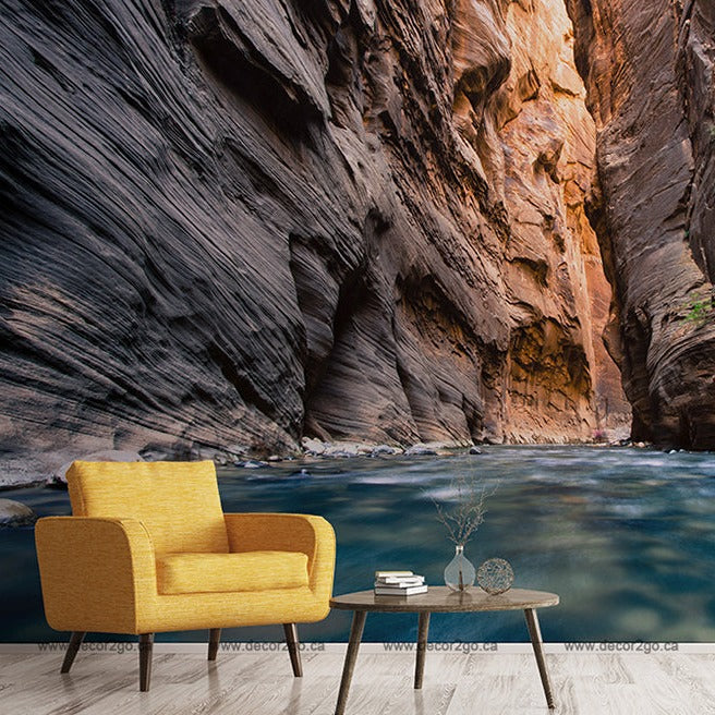 A surreal composite image featuring a vibrant yellow armchair and a small modern coffee table placed in a serene river flowing through Decor2Go Adventure Canyon Wallpaper Mural.