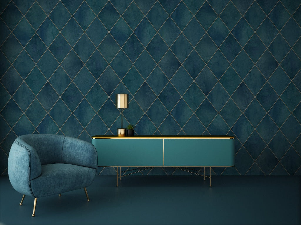 A minimalist living room featuring a teal sideboard with a lamp and vases on an Argyle Geometric Watercolor Art Wallpaper Mural background, accompanied by a cozy blue armchair from Decor2Go Wallpaper Mural.