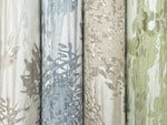 Four rolls of York Wallcoverings’ Aspen Grove Sand Wallpaper (60 SqFt) stand vertically, featuring abstract leafy patterns in beige, blue, tan, and green for a soft watercolor forest look with botanical appeal.