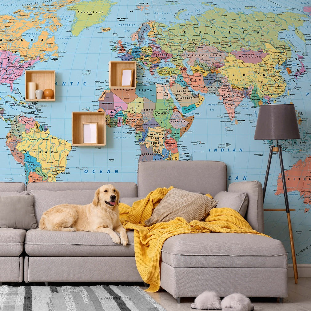 A golden retriever lounges on a gray sofa draped with a yellow blanket, in a room with a large Decor2Go Wallpaper Mural and minimalist decor.