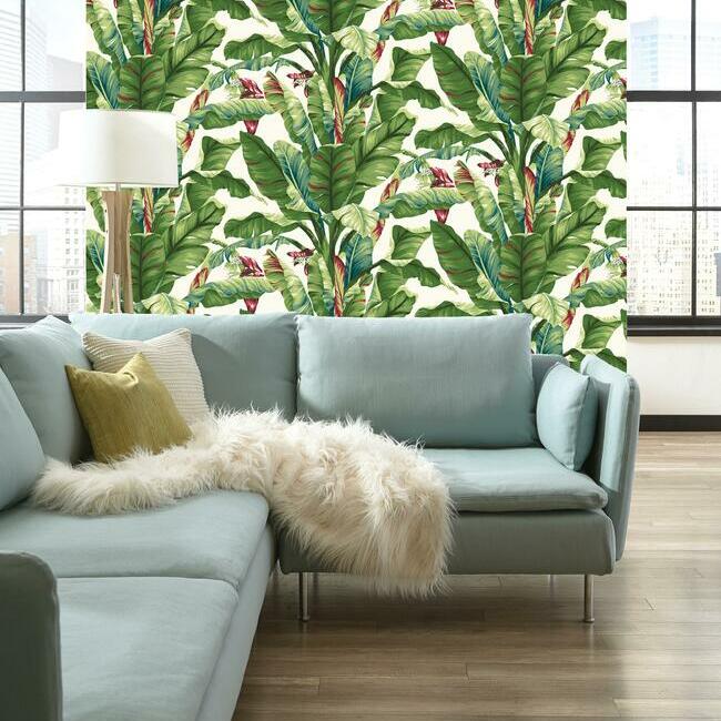 Banana Leave wallpaper in the living room behind blue sofa