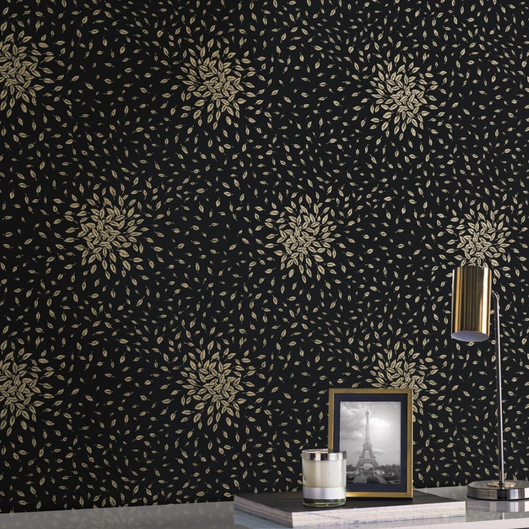 York Wallcoverings' Black & Gold Petite Leaves Wallpaper (60 SqFt) adorns the wall with its detailed gold floral design, accentuating contemporary interiors. A framed monochrome Eiffel Tower photo sits on a table with a metallic-finished lamp and small silver candle holder.