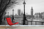 A **Black and White London Wallpaper Mural by Decor2Go Wallpaper Mural**, a nod to classic architectural design, adorns the wall. A modern red rocking chair is placed in front, adding a vibrant pop of color to the sophisticated setting.