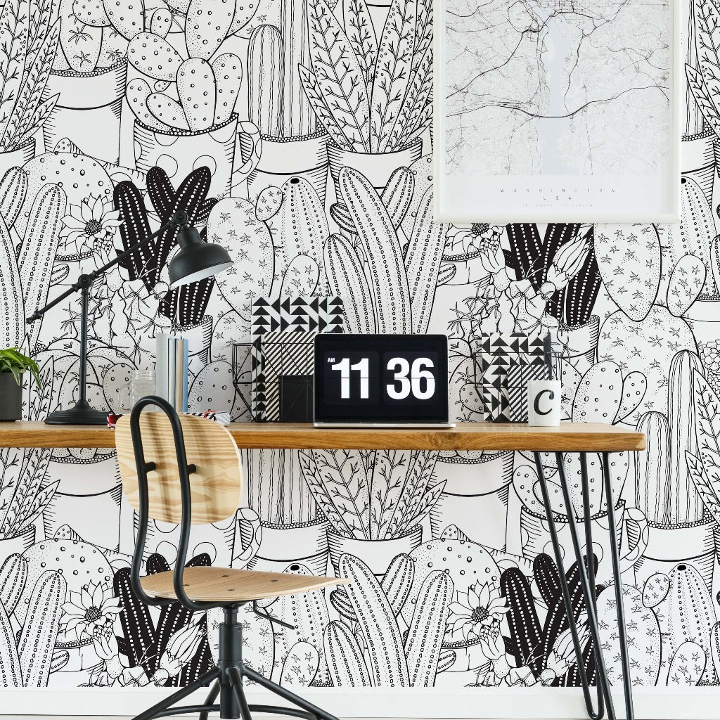 A stylish workspace featuring a wooden chair with a metal frame, a desk with Cactus Clan Wallpaper Mural decor from Decor2Go Wallpaper Mural, a digital clock showing 11:36, and a black lamp. The wall is adorned with.