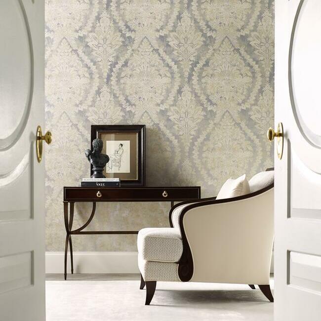 Elegant room with ornate Aqua Charleston Damask Wallpaper from York Wallcoverings, featuring a dark wooden console table with a framed picture, a bust sculpture, and a classic white upholstered chair with wooden legs.