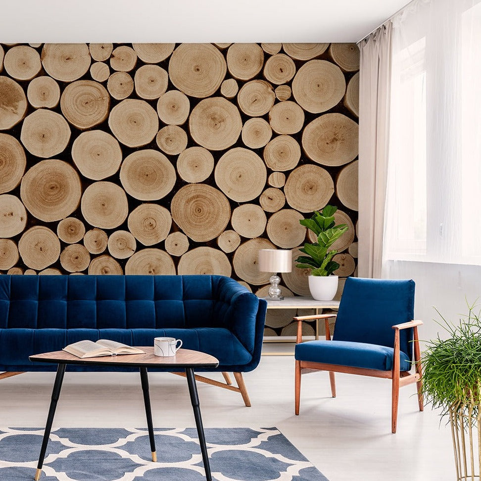 A stylish living room featuring a dark blue sofa, matching armchair, and a wall decorated with Decor2Go Wallpaper Mural. An elegant table, potted plants, and light curtains enhance the space.