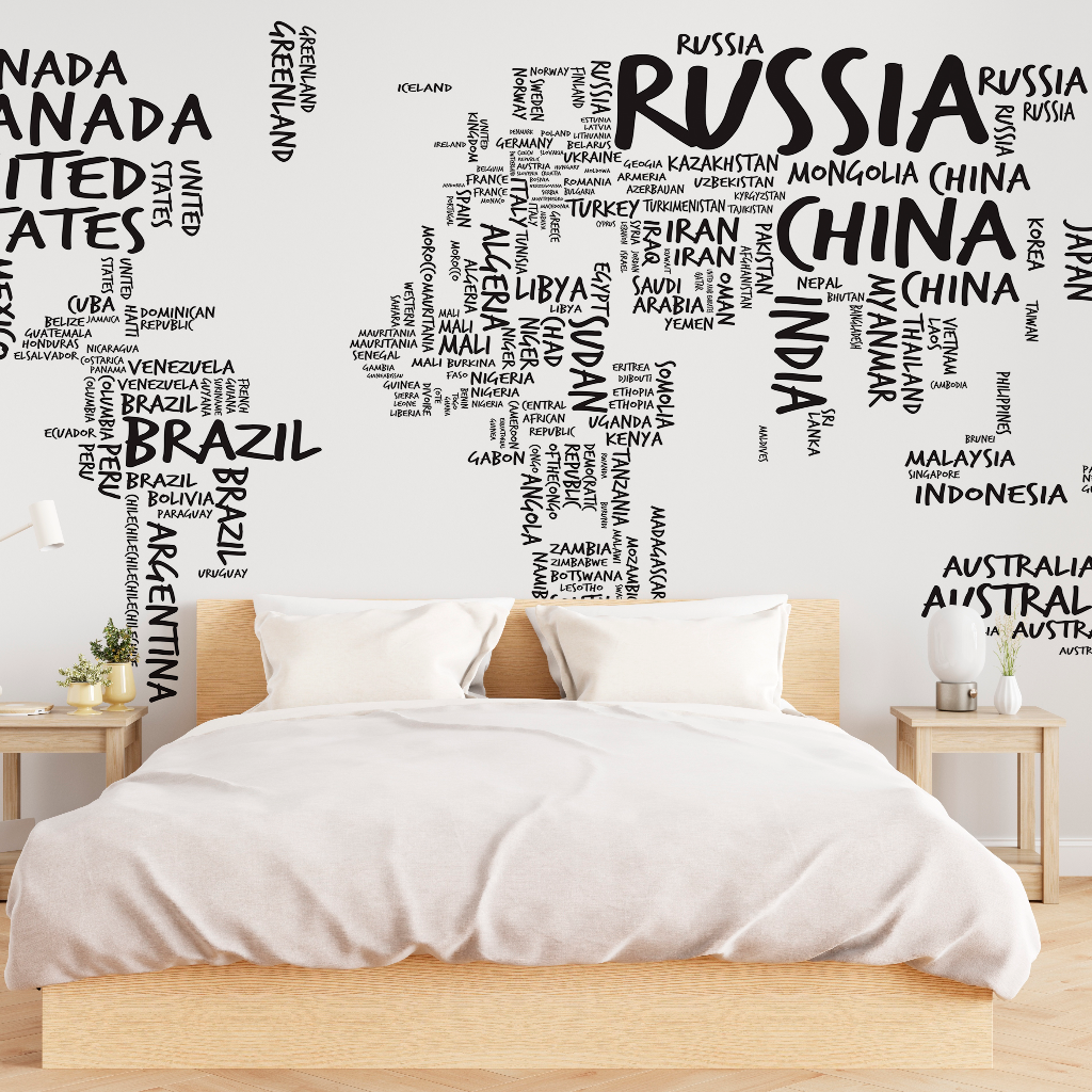 A modern bedroom with a plain white bedset against a vintage wall featuring a Decor2Go Wallpaper Mural Country Names Map made from black text of varying sizes and orientations.
