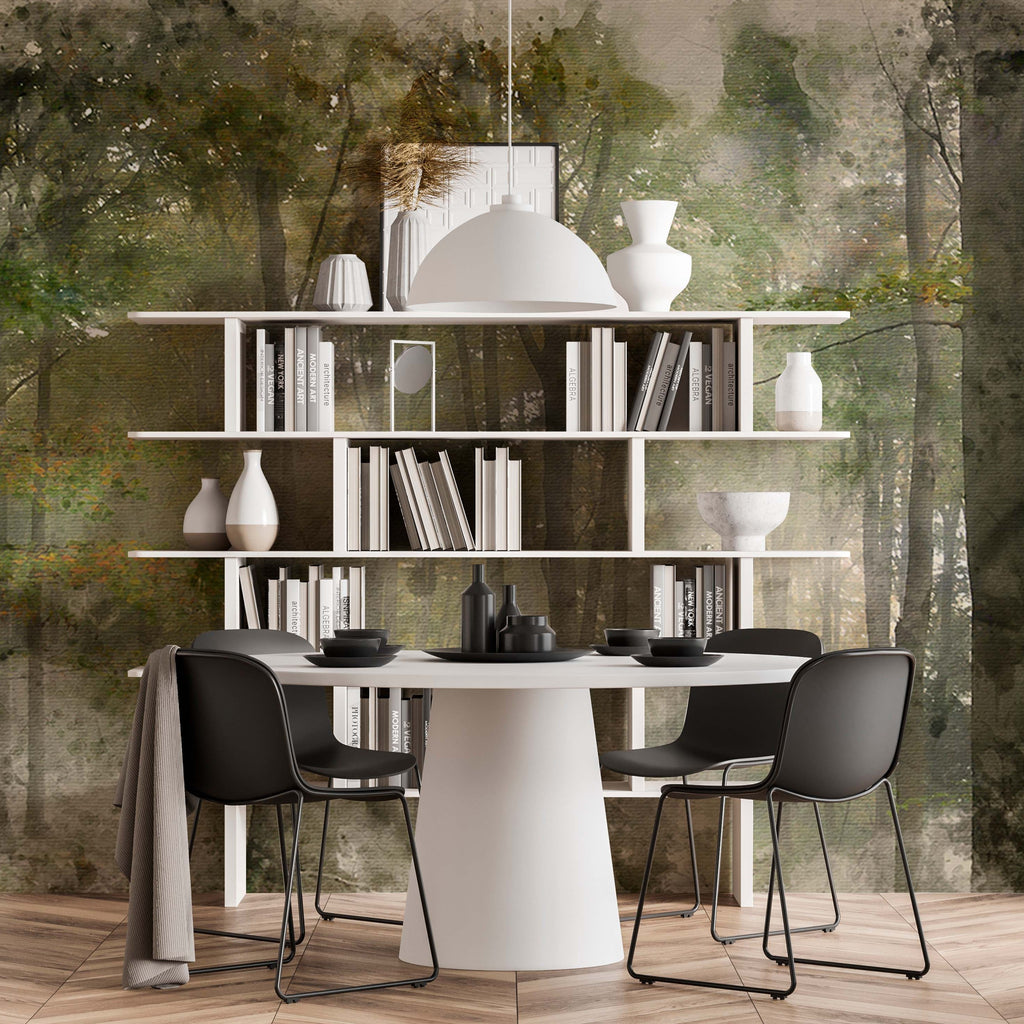 Modern dining area with a circular white table, two black chairs, and white shelves filled with books and decorative items, set against a Decor2Go Deep Forest Wallpaper Mural background.