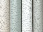 Four vertical rolls of York Wallcoverings' Dew Drop Grey Wallpaper (60 SqFt) in muted beige, green, and white shades, each featuring subtle diagonal silver dash patterns across the non-woven surface.