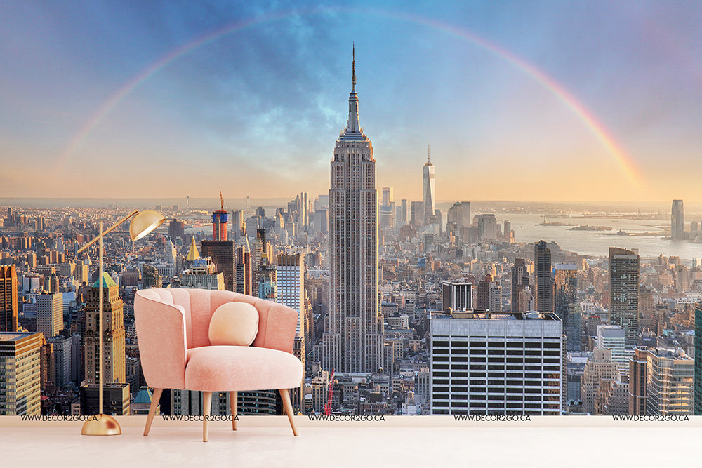 A whimsical image blending a stylish interior space with a Double Rainbow Skyline mural featuring the Empire State Building and a complete rainbow arching over the cityscape by Decor2Go Wallpaper Mural.