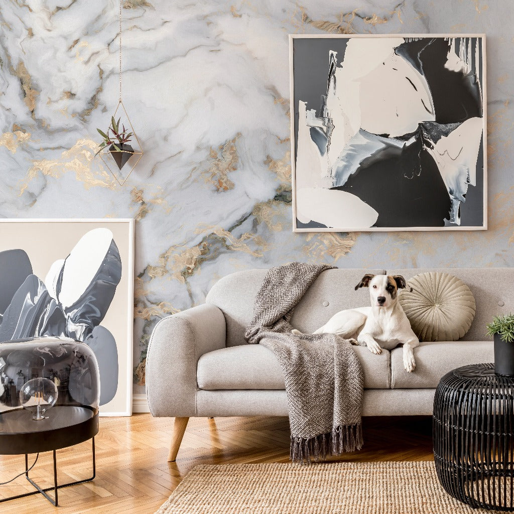 A stylish living room featuring Decor2Go Wallpaper Mural, with a beige sofa where a dog sits, modern art pieces, a glass side table, and textured decor accents.