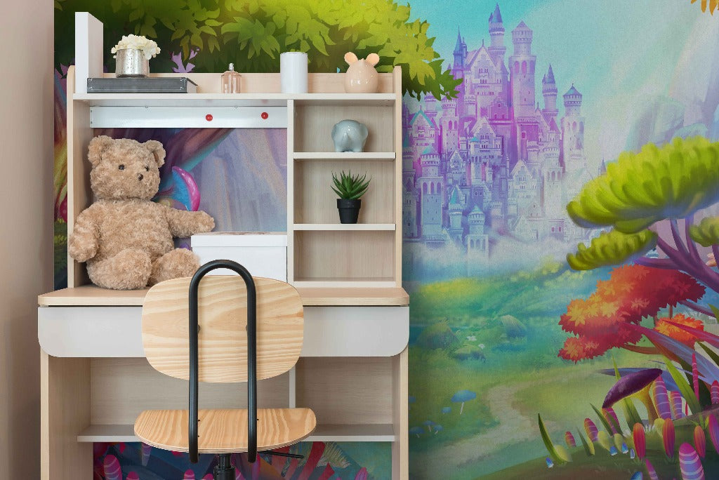 A child's room corner with a white shelving unit displaying a teddy bear, books, and decor items, next to Decor2Go Wallpaper Mural depicting a whimsical castle and vibrant fantasy landscape.
