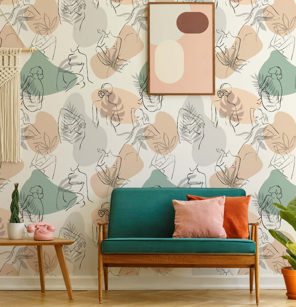 A stylish living space featuring a teal mid-century modern sofa with pink and orange pillows, a wooden frame, and a green plant beside it. The wall displays Decor2Go Wallpaper Mural Feminine Form  Wallpaper Mural with an abstract women's silhouette art piece hanging above.