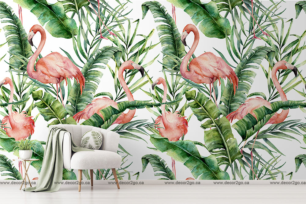 A stylish room featuring a large wall adorned with vibrant Decor2Go Wallpaper Mural depicting Flamingos and Tropical Leaves. In the foreground, there's a modern white chair with a throw blanket and a side table.