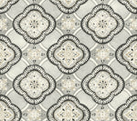 A patterned design featuring symmetrical, ornate shapes in shades of gray, white, and beige. The intricate motifs resemble stylized floral and geometric elements, forming a repeated lattice-like arrangement reminiscent of Garden Trellis Rain Wallpaper Blue, Grey (60 Sq.Ft.) by York Wallcoverings. The overall appearance is elegant and decorative.