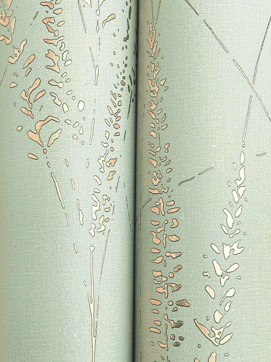Close-up of Graceful Willow Lagoon Wallpaper by York Wallcoverings, featuring a light green hue with subtle texture and abstract beige and tan grass-like designs. The seam between two panels is visible down the center. Covers 60 SqFt.