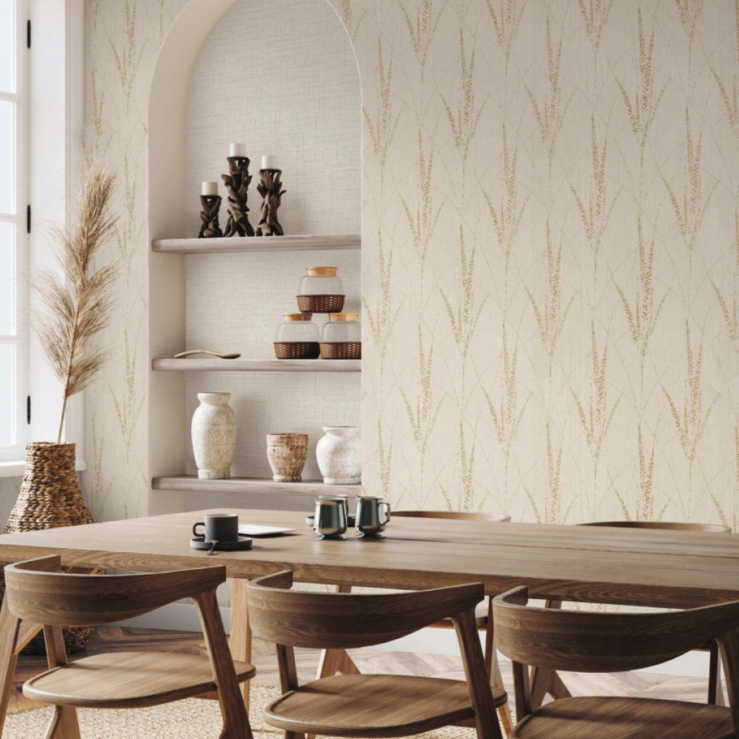 A dining area with wooden chairs and table, simple tableware, and shelves displaying vases and candles. Decor in earthy tones features York Wallcoverings’ Graceful Willow Pale Straw Wallpaper (60 SqFt) with a subtle vertical leaf pattern.