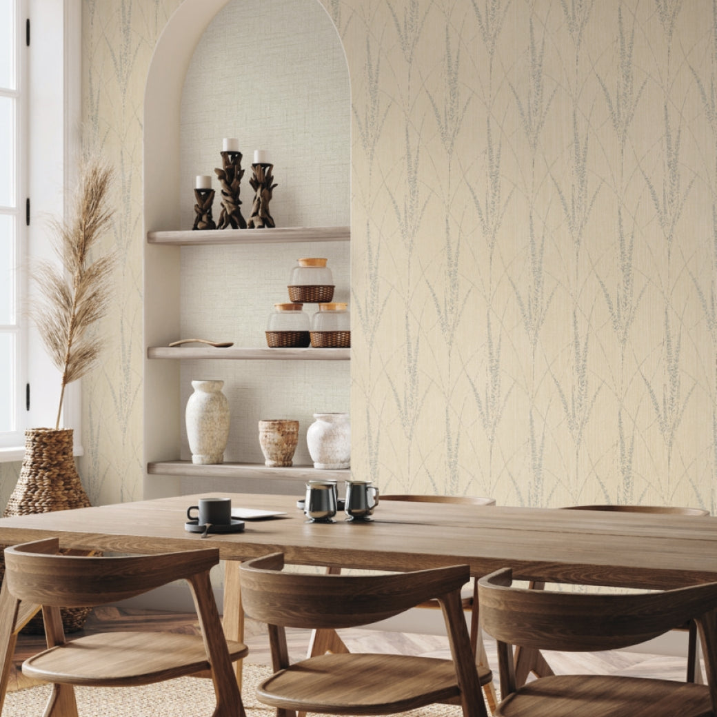 A modern dining room features a light wood table, six matching chairs, built-in shelves with vases and candles, and York Wallcoverings’ Graceful Willow Putty Wallpaper (60 SqFt), adding subtle elegance. A large window fills the space with natural light.
