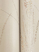 Close-up of an open book with textured, beige pages accented by gold-embossed designs resembling Graceful Willow Stone Wallpaper (York Wallcoverings, 60 SqFt). The book's spine is centered in the image.