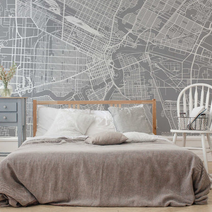 A modern bedroom with a grey Decor2Go Wallpaper Mural Winnipeg Wallpaper Mural, white rocking chair, and blue nightstand, against a wall featuring an architectural wall design of Winnipeg.