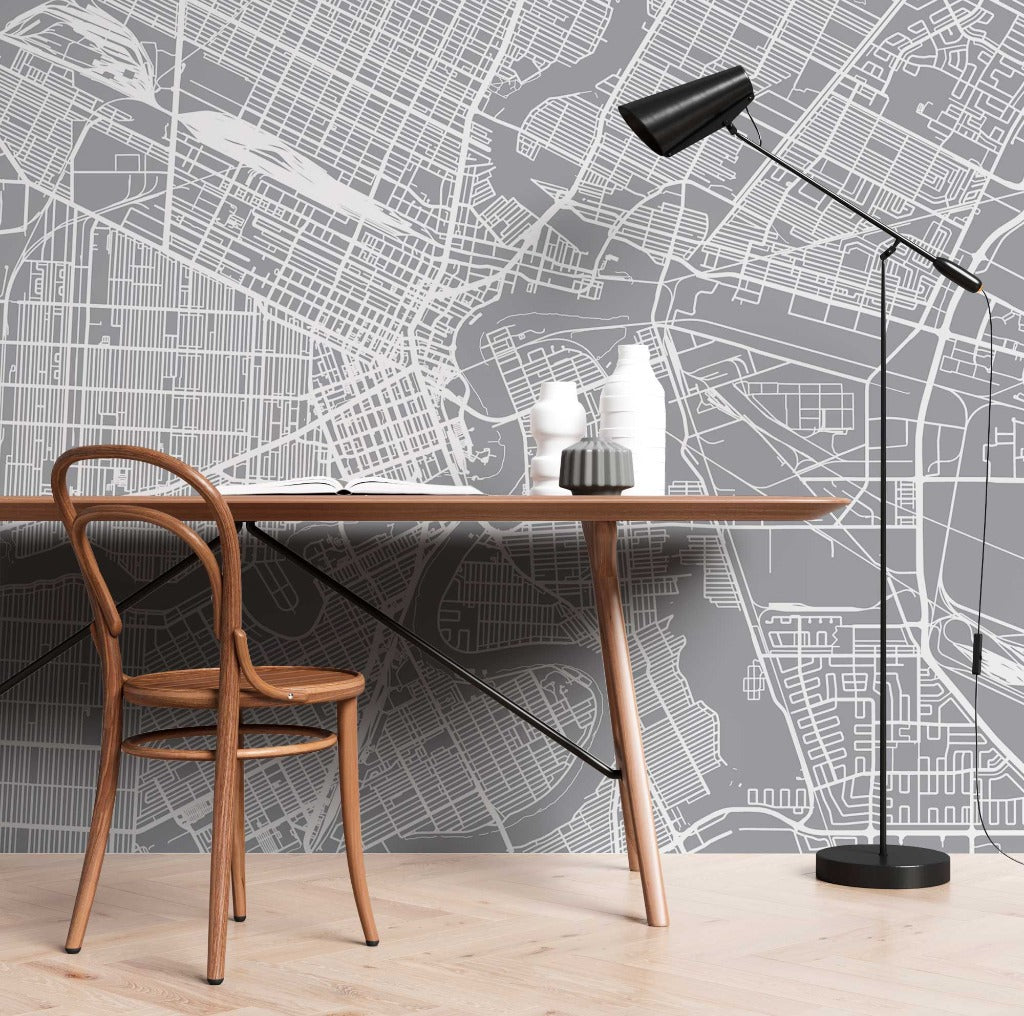 A stylish workspace featuring a bentwood chair and a white desk against a wall decorated with a large black and white Decor2Go Wallpaper Mural. A black floor lamp extends over the desk.