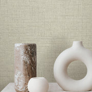 Three minimalist vases—a tall marbled, a small round, and an off-white vase with a circular opening—sit on a light surface against York Wallcoverings' Hillswick Tweed Fog Wallpaper (60 SqFt) for a textured beige backdrop.