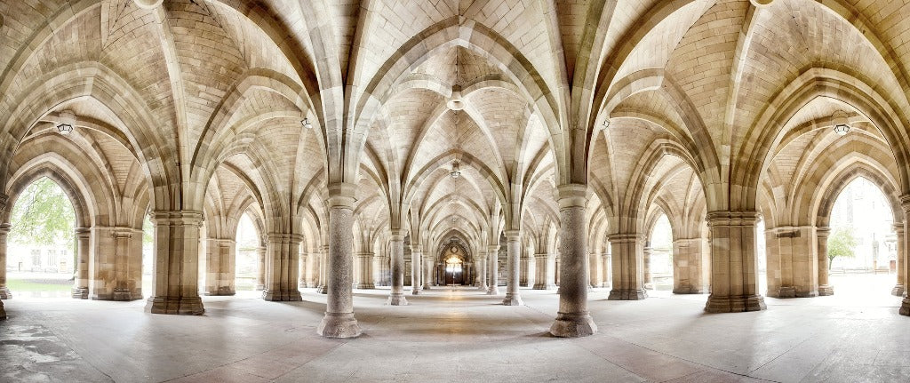 Panoramic view of a spacious, vaulted Glasgow University cloister with symmetrical arches and columns, illuminated by natural light, creating a serene and majestic atmosphere featuring the Infinite Paths Wallpaper Mural from Decor2Go Wallpaper Mural.