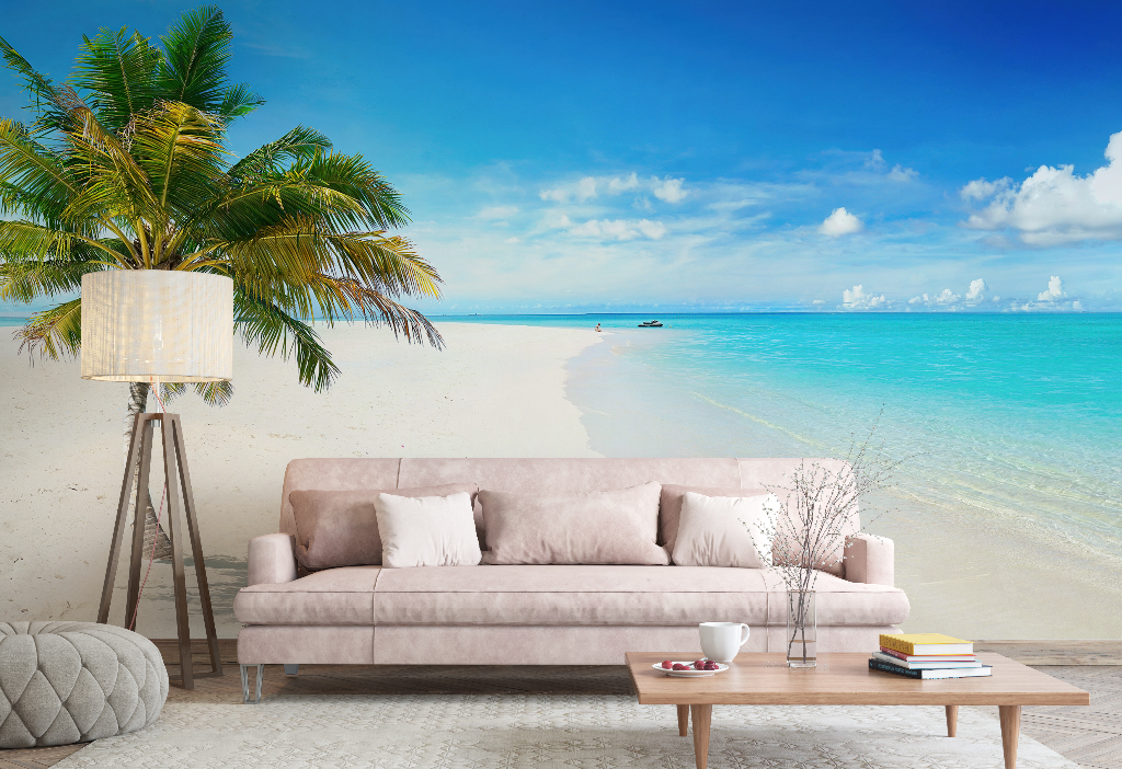Living Room - A cozy living room setup with a plush sofa and decorative pillows, a small coffee table with books and a cup, beside a tall lamp, all placed on a sandy floor against a vibrant Island in the Sun Wallpaper Mural by Decor2Go Wallpaper Mural.