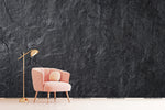 A pink armchair and a gold floor lamp stand against a textured Decor2Go Wallpaper Mural wall in a minimalist setting.