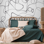 A stylish modern bedroom featuring a Decor2Go Wallpaper Mural on a white wall, with a rattan headboard, dark green bedding, a beige throw, and matching pillows.