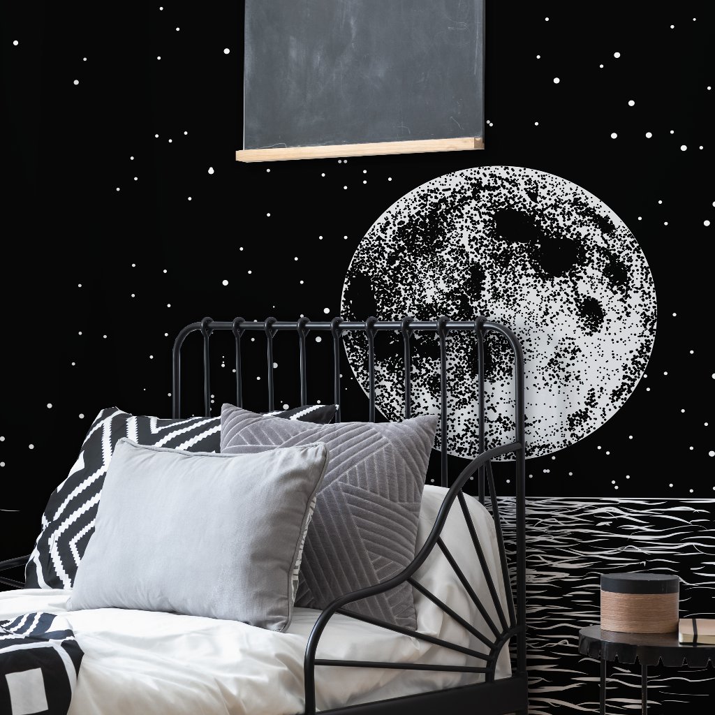 A stylish bedroom featuring a black metal bed with striped bedding, a Decor2Go Wallpaper Mural on the wall, and a floating chalkboard against a starry backdrop.