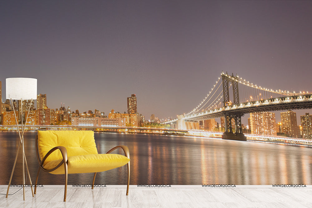 A vibrant yellow armchair and a white floor lamp beside a Decor2Go Wallpaper Mural overlooking the Manhattan's Night Sky Wallpaper.