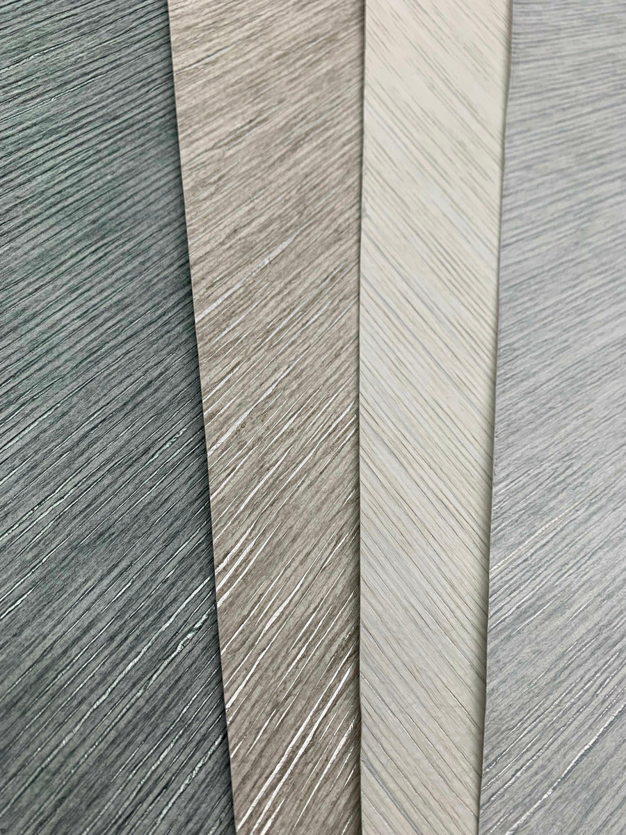 A close-up of three overlapping textured sheets in varying shades of gray and beige highlights a subtle, striped pattern reminiscent of the semi-transparent elegance offered by the Metallic Chevron Wallpaper Cream from Decor2Go Wallpaper Mural.