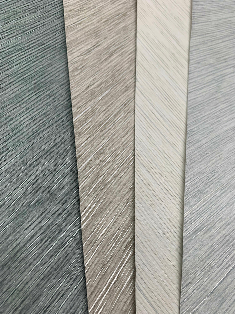 Four vertical samples of Metallic Chevron Wallpaper Cream from Decor2Go Winnipeg each have different textures and shades of gray, displayed side by side to show variety.