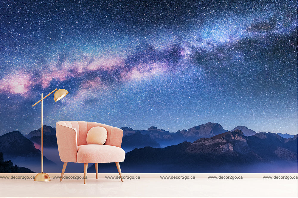A digital room setup with a stylish pink armchair and a gold floor lamp, overlooking a scenic backdrop of mountainous terrain under a Decor2Go Wallpaper Mural Milky Way Mountains wallpaper mural.