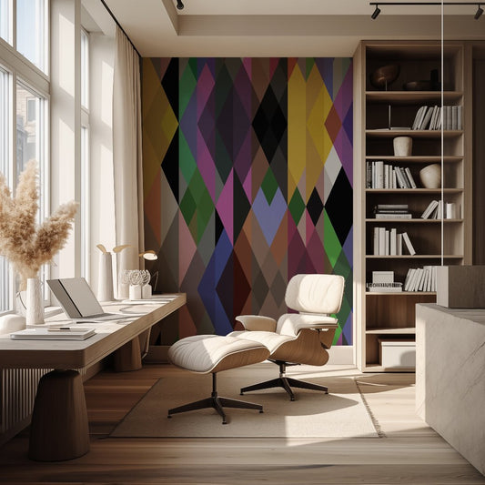 A contemporary home office features a white lounge chair and ottoman, a wooden desk with a laptop, and decorative items. The wall behind the chair is adorned with the Modern Geometric Shapes Wallpaper Mural by Decor2Go Winnipeg. Large windows to the left allow natural light to flood the space, enhancing its vibrant color palette.