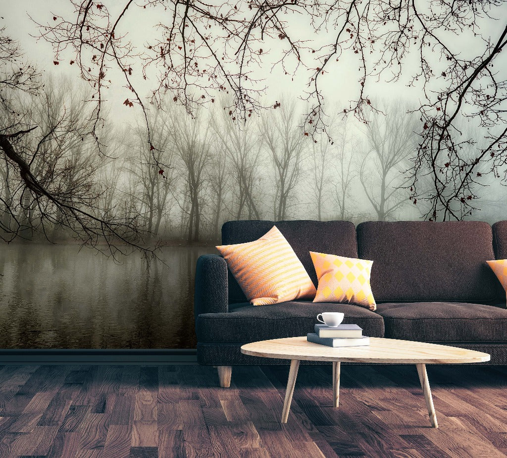 A serene living room featuring a dark gray couch with vibrant pillows, a small white coffee table with a cup, set against a Decor2Go Wallpaper Mural of Murky Forest Wallpaper Mural.