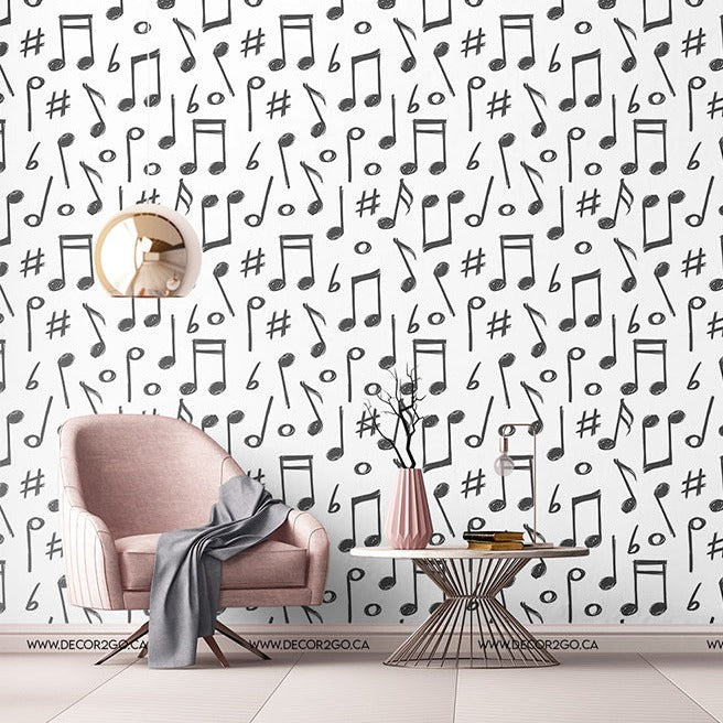 A stylish room with a pink armchair and gray throw blanket, a round side table with books, standing lamp, and a white wall with Decor2Go Wallpaper Mural Music Notes wallpaper pattern.