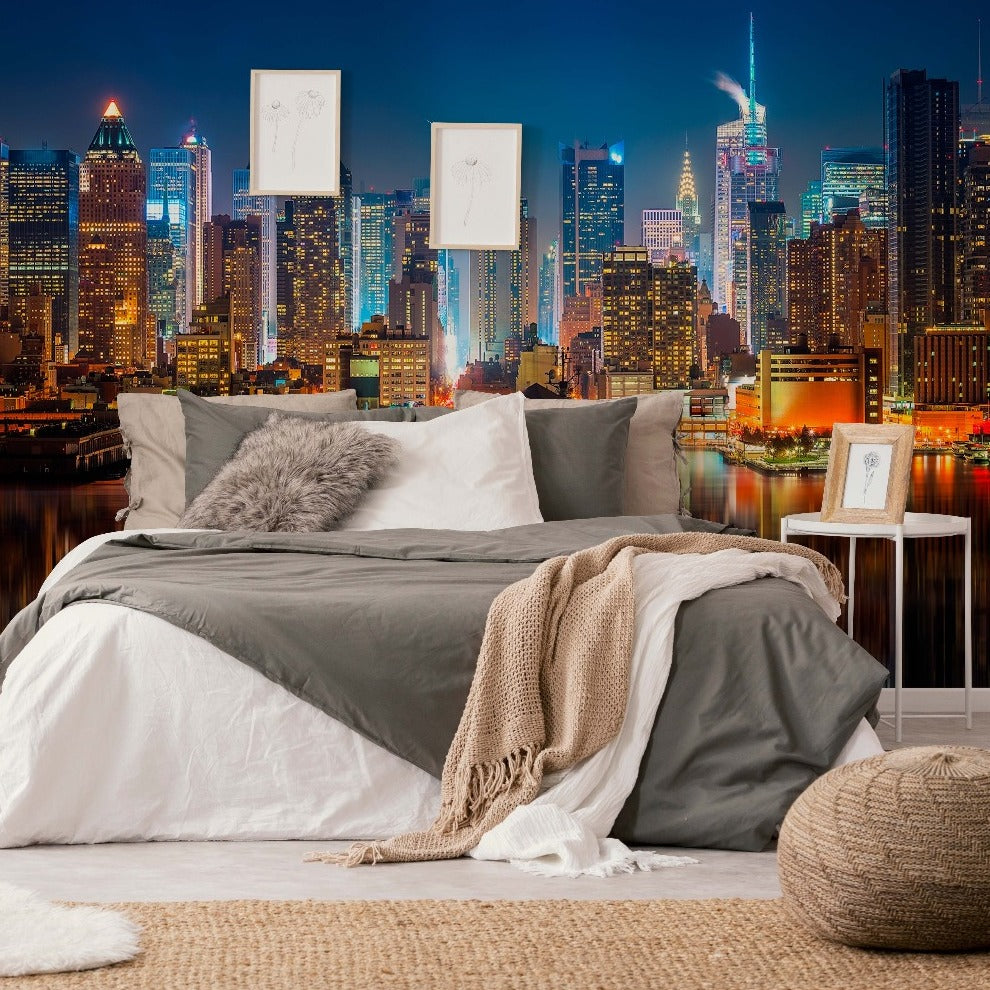 A stylish bedroom setup with a large bed covered in white and gray bedding and a plush throw, facing an expansive Decor2Go Wallpaper Mural through the wall-sized window.