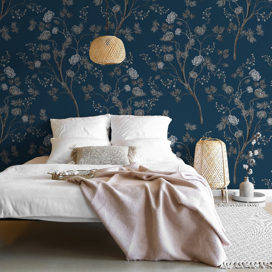 A serene bedroom featuring a low bed with white bedding and a soft pink throw, against a Decor2Go Wallpaper Mural. A woven pendant light and a rattan nightstand add a natural touch.