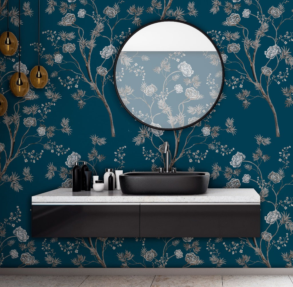 Modern bathroom with a dark-themed basin and faucet on a gray vanity against a Decor2Go Wallpaper Mural. A round mirror and wall-mounted gold lamps complete the scene.